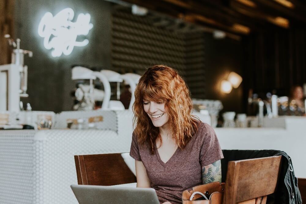 Red head girl in cafe with computer